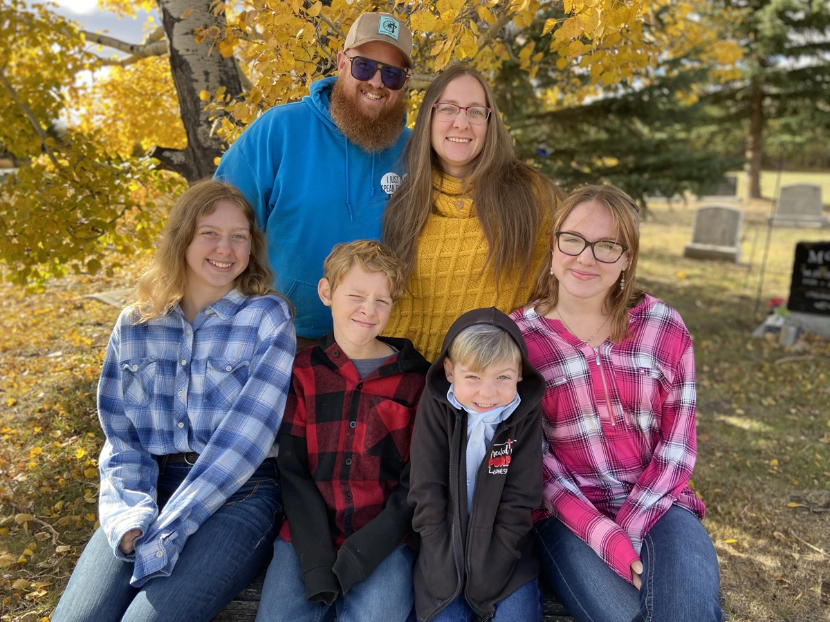 Bryce with his family beneath golden autumn leaves.